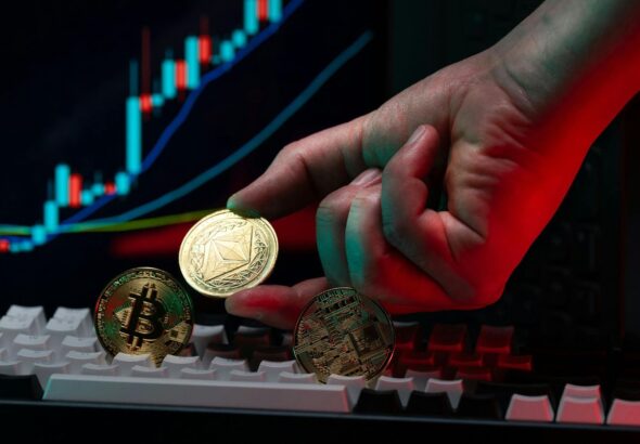 Hand Holding Cryptocurrency Coins with Graph Background